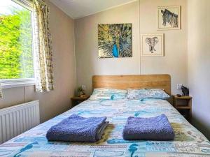 a bedroom with a bed with two pillows on it at Dog Friendly 8 Berth Static Caravan Newquay in Newquay