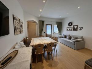 a living room with a table and a couch at Appartamento Continental - 8 posti letto in San Vito di Cadore