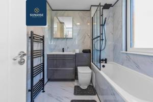 a bathroom with a tub and a toilet and a sink at Springhill Townhouse - INVOICE and REDUCED PRICE only via SUNRISE SHORT LETS DUNDEE, 3 Bedrooms, 2 Kings, 1 Single, Great Views, Newly Refurbished, Free Parking, Free Wifi, River View, Dock, Eden Views in Dundee +25 photos
