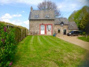 a brick house with a car parked in front of it at La Perruche Holiday Gite in Heussé