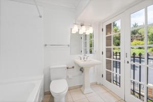 a white bathroom with a toilet and a sink at Santa Rosa Stonehouse Private Wine Country Retreat! in Bak