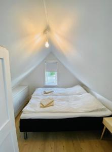 a small bedroom with a bed in a attic at Charming house downtown - the whole house or a bedroom - you choose! in Tórshavn +2 photos
