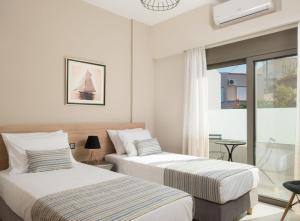 two beds in a room with a window at Leya villa in Tavronitis