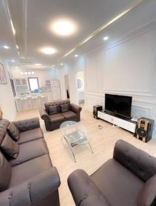 un salon avec des canapés et une télévision à écran plat dans l'établissement Villa Kota Bunga Aeshtetic By akuvilla, à Cikundul