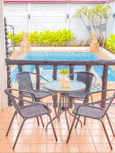 - une table et des chaises à côté de la piscine dans l'établissement Villa Kota Bunga Aeshtetic By akuvilla, à Cikundul