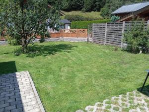 a backyard with a fence and a grass yard at Ferienwohnung Maier in Mittersill
