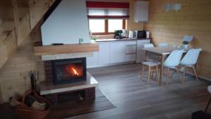 a kitchen with a fireplace and a table and chairs at Domki Pod Biegunem, Strefa Relaksu, Bajkowy Świat Smerfów in Żywiec