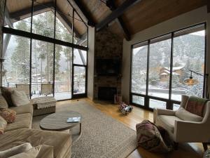 a living room with a couch and chairs and windows at Mountain Retreat in Frisco