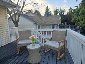 two chairs and a vase of flowers on a deck at Tranquility Residence in Apple Valley