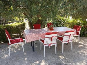 a table with four chairs and a red and white table and chairsktop at La Hacienda DD in Trebinje