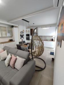 a living room with a gray couch with pillows at Casa ElaBon - Rozzano Vicino Humanitas, IEO, Forum Assago, Duomo in Rozzano