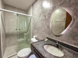 a bathroom with a sink and a shower and a mirror at Pousada Naala in Porto De Galinhas +49 photos