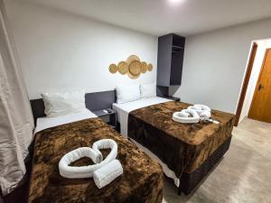 a hotel room with two beds with towels on them at Pousada Naala in Porto De Galinhas