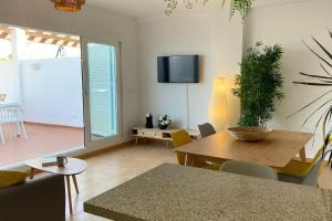 莫哈卡尔Mojacar 1ª linea playa vacaciones的带餐桌和电视的客厅