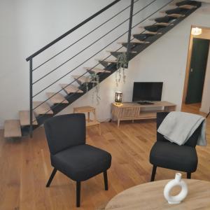 sala de estar con 2 sillas y escalera en Renaissance, en Montpellier