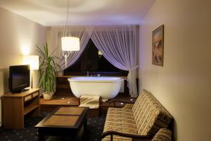 een kamer met een bad en een kamer met een televisie bij Park Villa in Vilnius