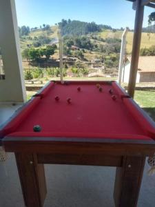 a red pool table in front of a window at CHÁCARA KAUANNY SOCORRO SP in Socorro