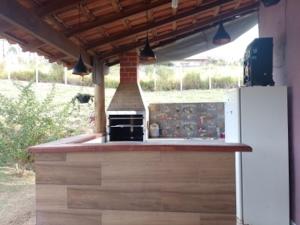 an outdoor kitchen with a stove and a refrigerator at CHÁCARA KAUANNY SOCORRO SP in Socorro
