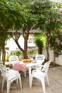 Villa Sa Calma Beach Sa Riera في بيغور: طاولة بيضاء وكراسي على فناء به اشجار