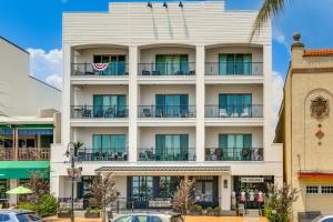 an image of a white building with blue windows at Downtown Bay St Louis Condo - Walk to Beach! in Bay Saint Louis