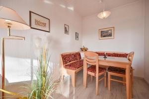 Zimmer mit einem Tisch, Stühlen und einem Schreibtisch in der Unterkunft Bungalow Vaupel in Kellenhusen