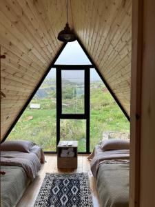 A bed or beds in a room at Kazbegi cottage kide- ყაზბეგში კოტეჯი კიდე
