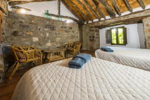 ein Schlafzimmer mit zwei Betten und einem Tisch und Stühlen in der Unterkunft Cortijo Rural Las Nogueras in Cortijada Los Chorreros + 77 Fotos