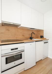 a kitchen with white cabinets and a sink at La gran plaza de candanchu in Candanchú