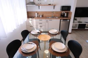 a kitchen with a table and chairs and a kitchen with a sink at Seaside Serenity "Earth" with pool, 150m from sea in Sukošan +21 photos