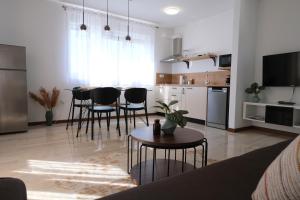 a kitchen and living room with a table and chairs at Seaside Serenity "Earth" with pool, 150m from sea in Sukošan