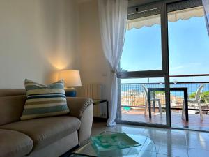 a living room with a couch and a view of a patio at Maison Panorama - Portofino View in Lavagna