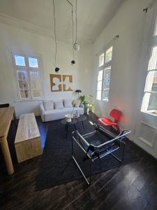 a living room with a white couch and red chairs at La Puerta Roja in Valparaíso
