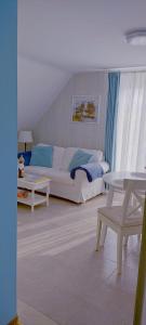 a living room with a white couch and a table at Ferienwohnung Schmetterling II in Grossenbrode