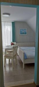 a bedroom with a table and a bed and a table and chair at Ferienwohnung Schmetterling II in Grossenbrode