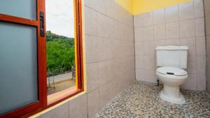 a bathroom with a toilet and a window at La Playa hostel in Mazunte