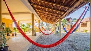 a group of red and blue hammocks hanging from a building at La Playa hostel in Mazunte