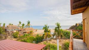 a view of the beach from the balcony of a house at La Playa hostel in Mazunte