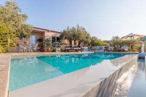 einen Pool mit blauem Wasser vor einem Haus in der Unterkunft Skopelos Blue Heaven Pool Villa in olive grove in Skopelos