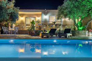 ein Haus mit Swimmingpool bei Nacht in der Unterkunft Skopelos Blue Heaven Pool Villa in olive grove in Skopelos + 50 Fotos