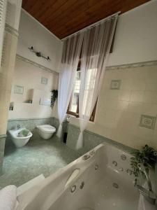 a bathroom with a tub and a toilet and a sink at via Manara 3 in Cantù