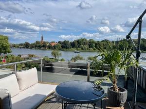 a balcony with a couch and a table and a river at Ferienhaus Seekutter mit eigenem Seezugang in Malchow
