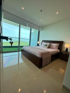 une chambre avec un grand lit et une grande fenêtre dans l'établissement Playa Boquilla -Condo Hotel Sonnesta Cartagena- Vista hermosa a la Ciénaga piso Alto, à Carthagène des Indes 26 autres photos