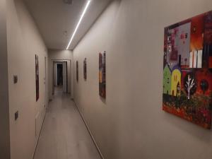 einen langen Flur mit Gemälden an den Wänden in der Unterkunft Smart Apartment Sei Chiese - TWA in Bologna
