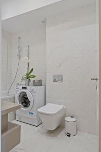 bagno bianco con lavatrice e servizi igienici di My Place Residence a Voluntari Altre 34 foto