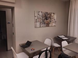 ein Esszimmer mit einem Tisch und weißen Stühlen in der Unterkunft Smart Apartment Sei Chiese - TWA in Bologna