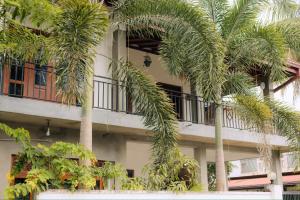 a building with palm trees in front of it at Falkennest Villa in Wadduwa