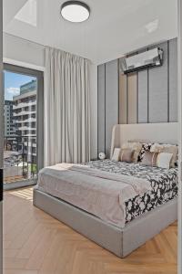 una camera da letto con un letto grande e una grande finestra di My Place Residence a Voluntari