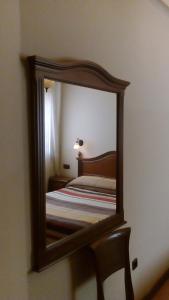 een spiegel die een bed in een kamer reflecteert bij Hostal Granada in Salamanca