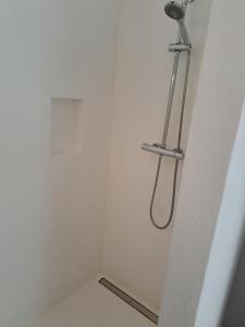 ducha en una habitación blanca con cabezal de ducha en Deluxe Room Santa Barbara de Nexe, en Santa Bárbara de Nexe