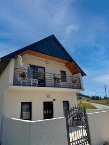 ŠavnikにあるBukovica Guest Houseの白い家(花の咲くバルコニー付)